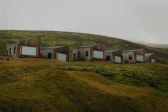A group of buildings sitting on top of a lush green hillside