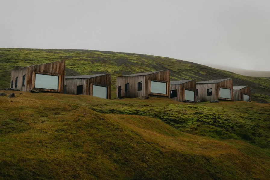 A group of buildings sitting on top of a lush green hillside