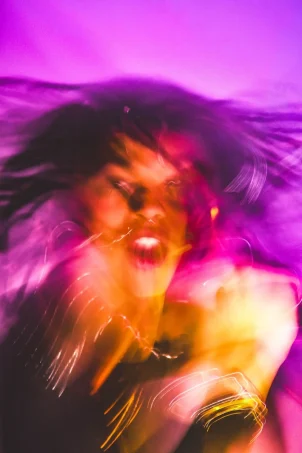 A blurry photo of a woman with her hair blowing in the wind