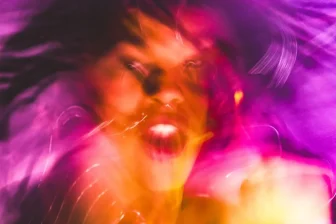 A blurry photo of a woman with her hair blowing in the wind